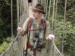 visitor with camera crossing canopy walkway kakum national park