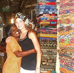 Woman seller embracing visitor at a marking in Ghana