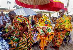 Men in Kente greeting at a festival