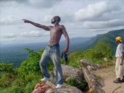 shirtless man celebrating at summit of mt afadjato