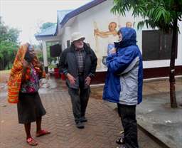 three people standing in rain in ghana