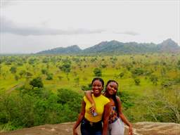 two women smiling in front of shai hills scenic view